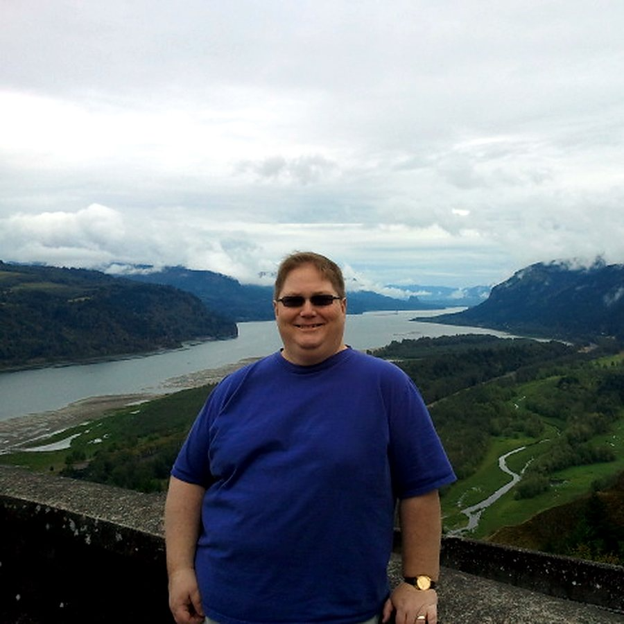 Dave Parker smiling at a scenic river overlook